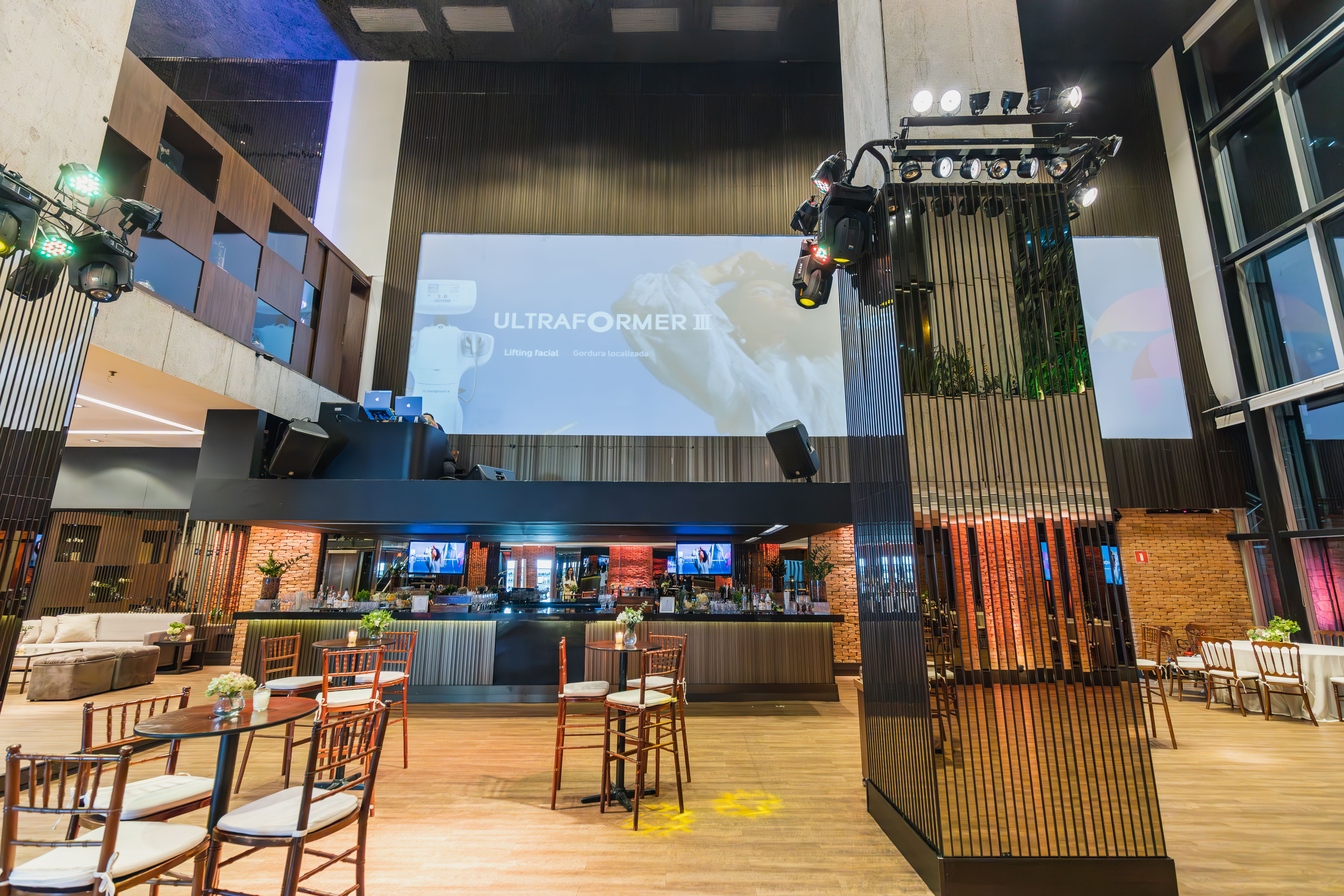Salón de eventos con barra y mesas altas para convenciones